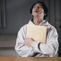 A4封筒を胸に抱きしめる安堵の男性の写真