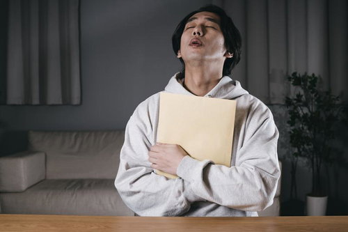 A4封筒を胸に抱きしめる安堵の男性