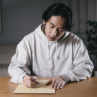 あとは封筒に送り先を記入して郵送するだけの男性の写真