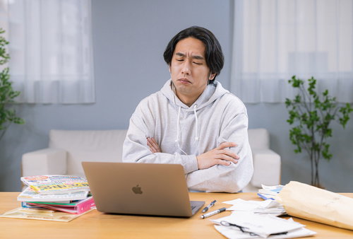 税理士のアドバイスに納得がいかず腕を組んで考える男性