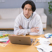 確定申告の書類に困惑する男性の写真