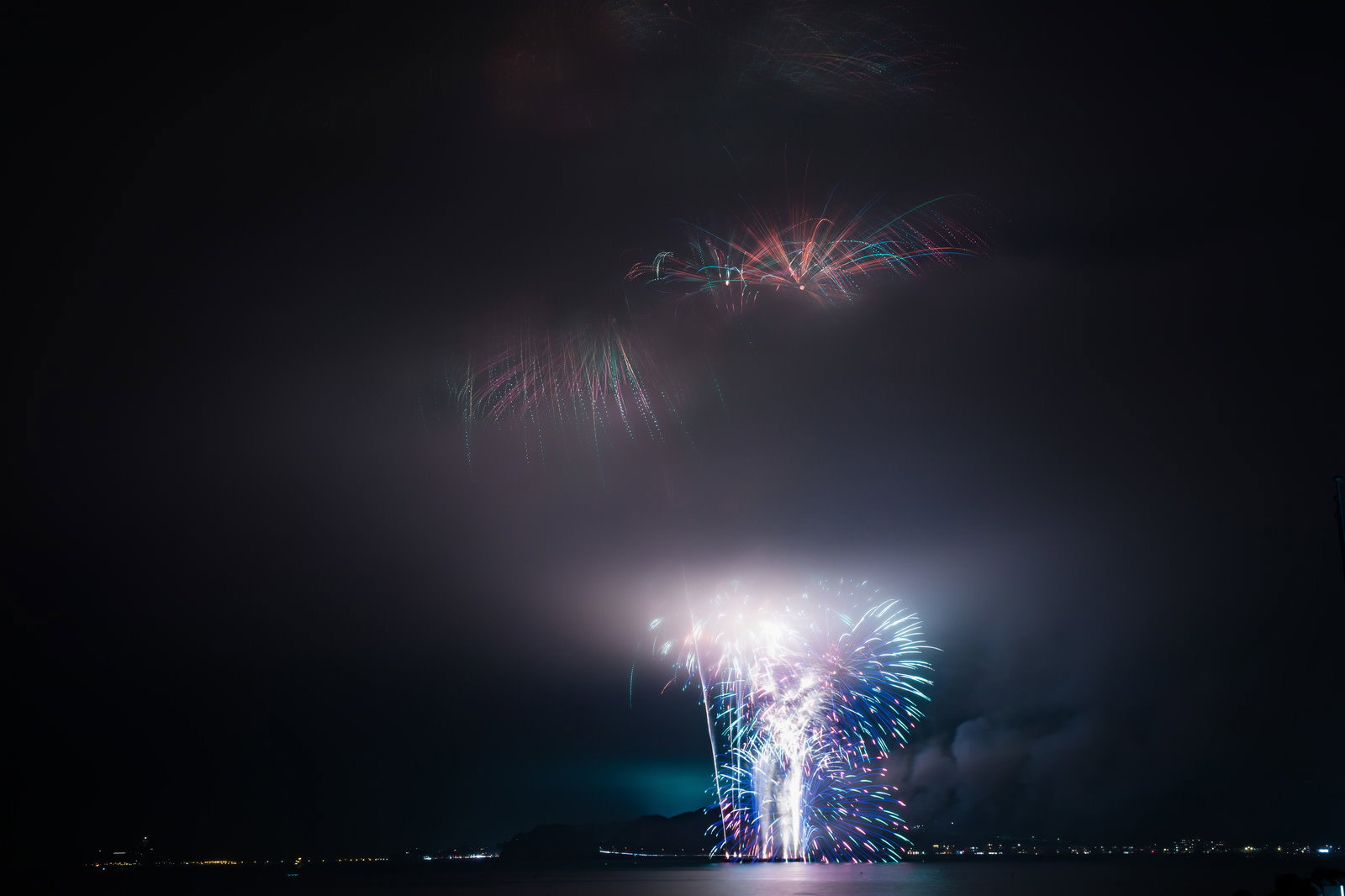 煙に包まれた夜の海上花火大会