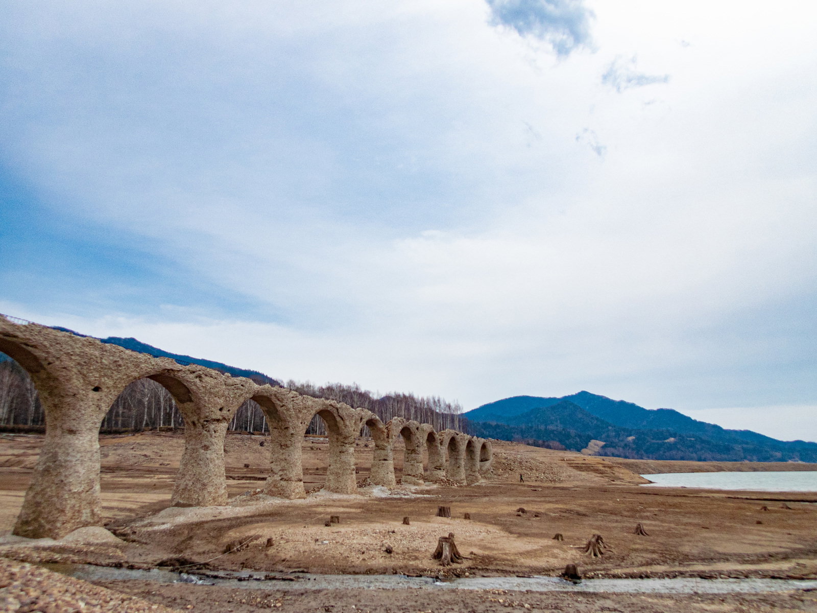 糠平湖の湖底に現れた石造アーチ橋タウシュベツ川橋梁と山々