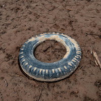 泥の湖底に放置されたタイヤの写真