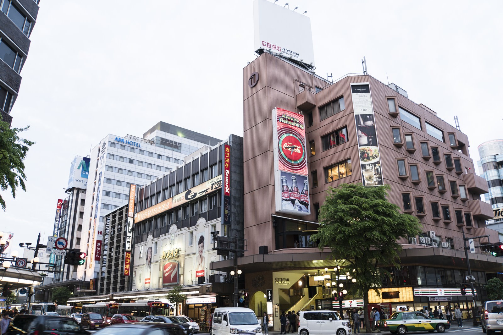 金沢片町の交差点で人々と車が行き交う繁華街の昼間の風景