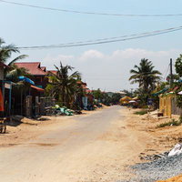 カンボジアの田舎道沿いに広がる赤い瓦屋根の家並みの写真