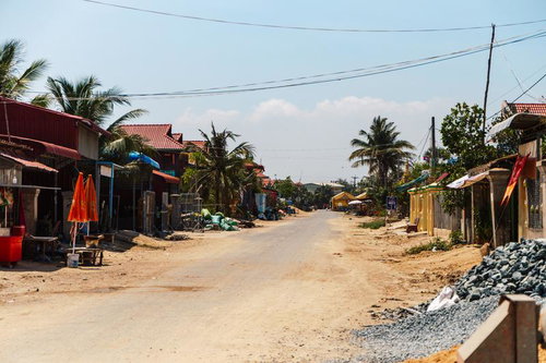 カンボジアの田舎道沿いに広がる赤い瓦屋根の家並み