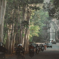 シェムリアップ近郊にある「アンコール・トム（Angkor Thom）」の南大門を通過するバイクと車の写真