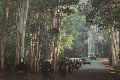 シェムリアップ近郊にある「アンコール・トム（Angkor Thom）」の南大門を通過するバイクと車