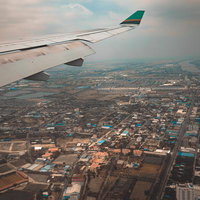 飛行機の窓際席から撮影したカンボジア上空の都市風景と主翼の写真