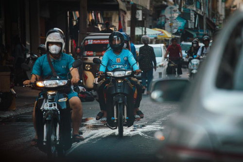 カンボジアの細い市街地の通りをバイクが走り抜ける