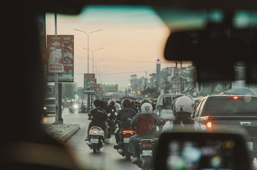 カンボジアの渋滞した道路でバイクの列に乗る人たち