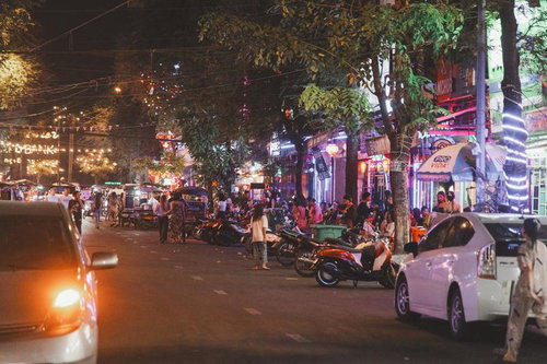 カンボジアの繁華街にある屋台や飲食店が並ぶネオンが輝く夜の通り