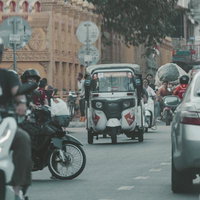 カンボジアの街中を走るトゥクトゥクとタクシーの写真