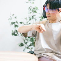 ARグラス越しに腕時計で時間を確認する男性の写真