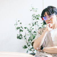 ARグラスで映し出されるビジョンに頭を抱える会社経営者の写真