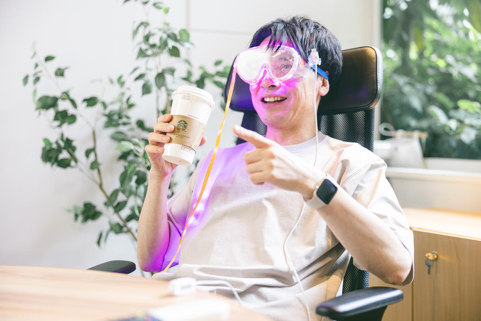 ARゴーグルを着けてコーヒーを飲みながら映画を視聴する男性［モデル：金子周平］