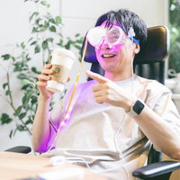 ARゴーグルを装着してオフィスで映画鑑賞する男性の写真