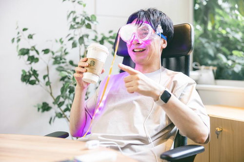 ARゴーグルを装着してオフィスで映画鑑賞する男性