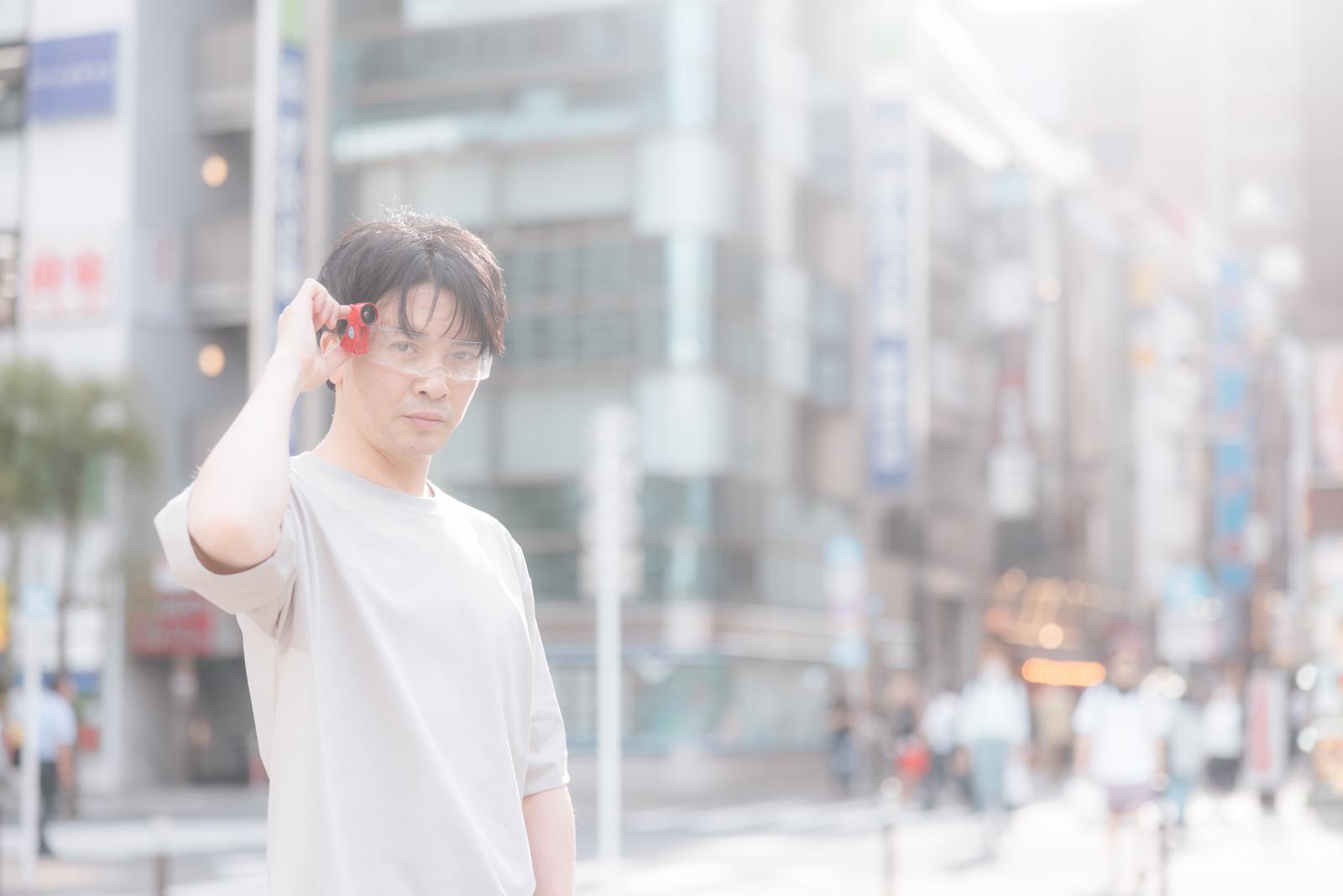 赤いレンズのARグラスを装着してスキャンする白いTシャツの男性［モデル：金子周平］