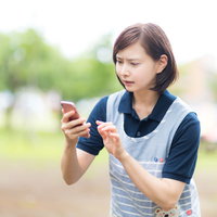 迷子をスマホのGPSで探す困惑した介護士の写真