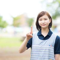 いちばん大切なことを示す人差し指を立てる制服姿の女性の写真