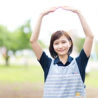 公園で大きくOKポーズをするヘルパーさんの写真