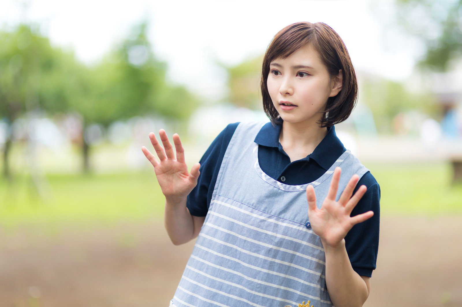 両手を広げて驚いた表情を見せる女性介護士ヘルパー［モデル：yumiko］