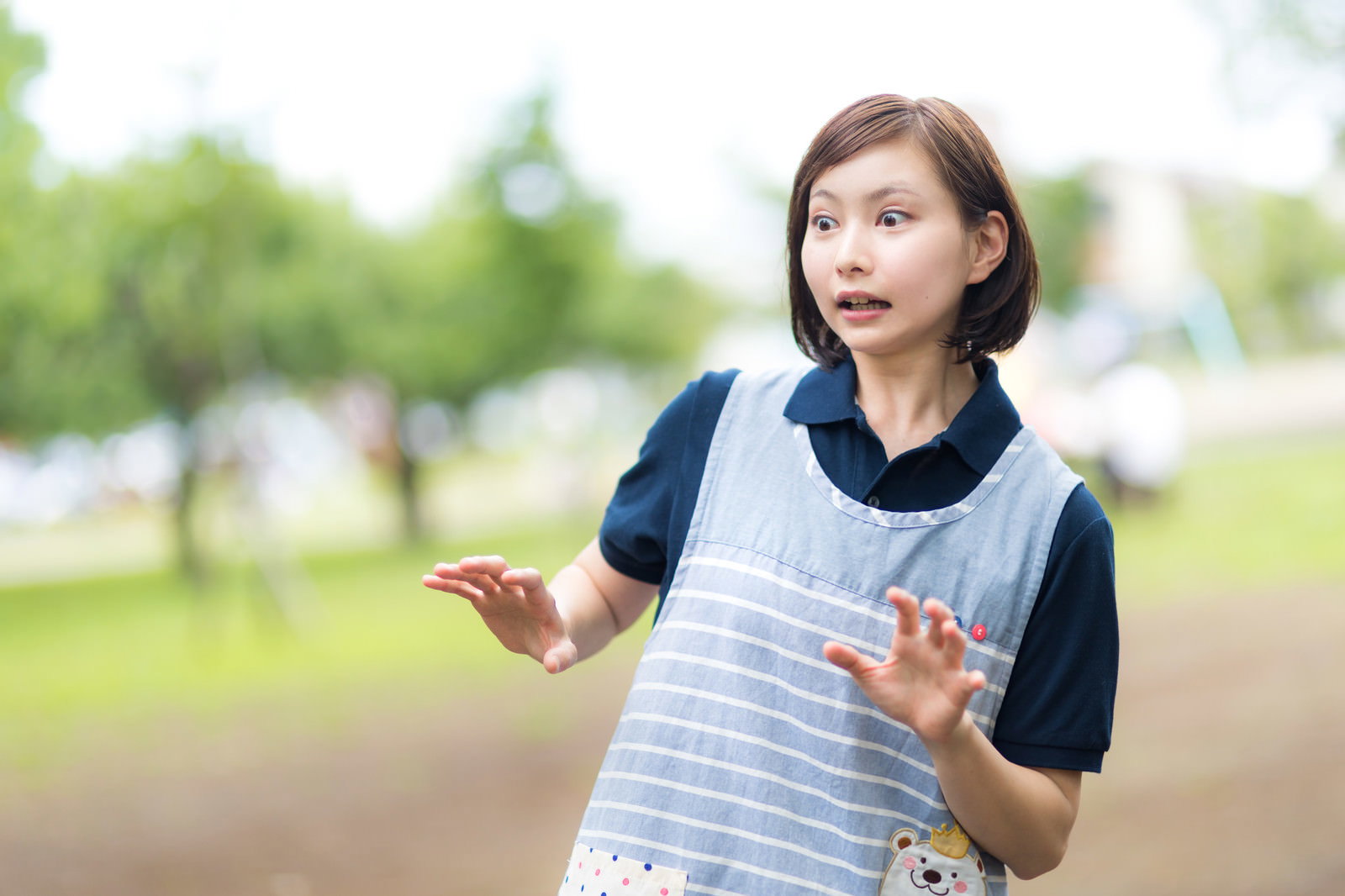エプロンを着た女性が両手を広げて驚いている表情［モデル：yumiko］