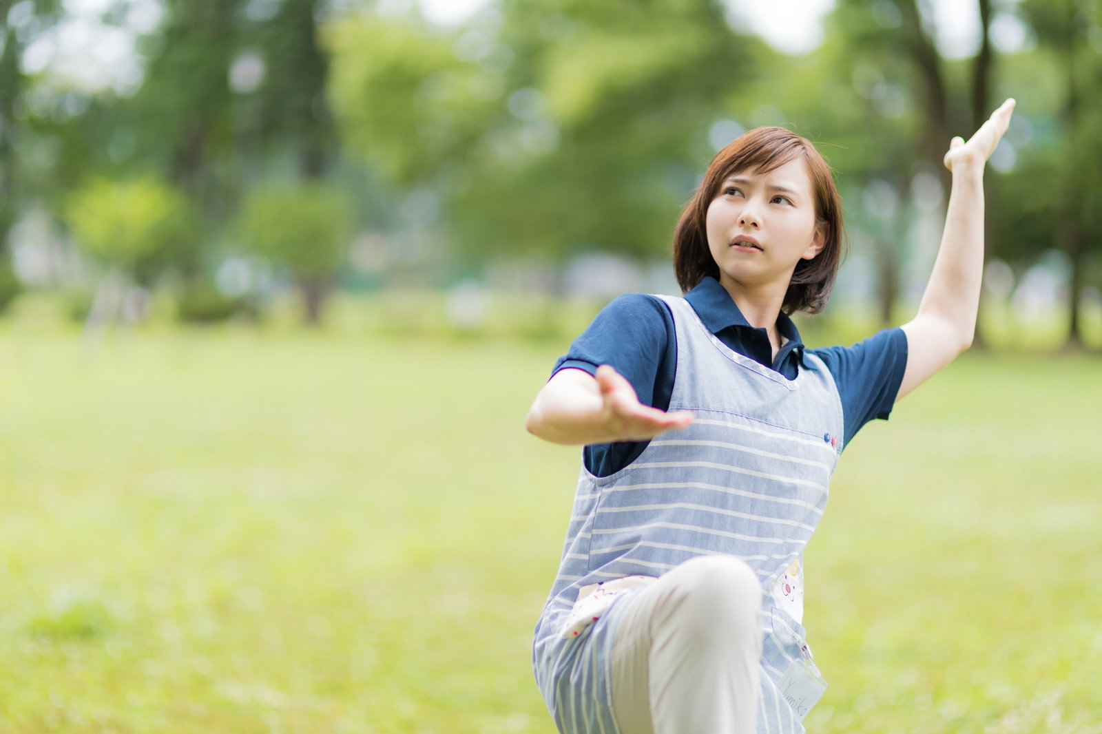 公園で太極拳の動作をするグレーのウェアを着た女性［モデル：yumiko］