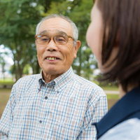 公園で会話する高齢者（86歳）とヘルパーの女性の写真
