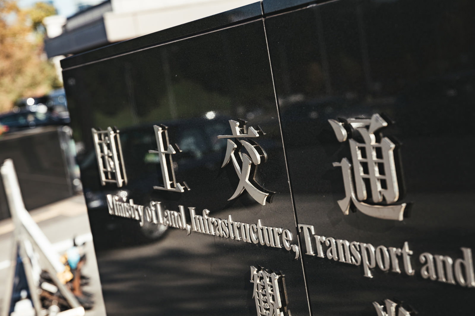 黒い背景に白い文字で国土交通省と刻まれた銘板