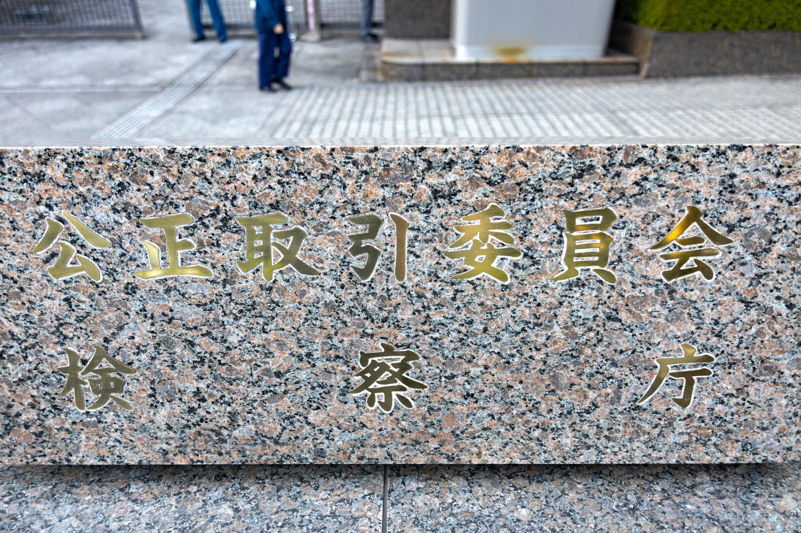 石材に彫られた公正取引委員会と検察庁の銘板が並んで設置されている様子