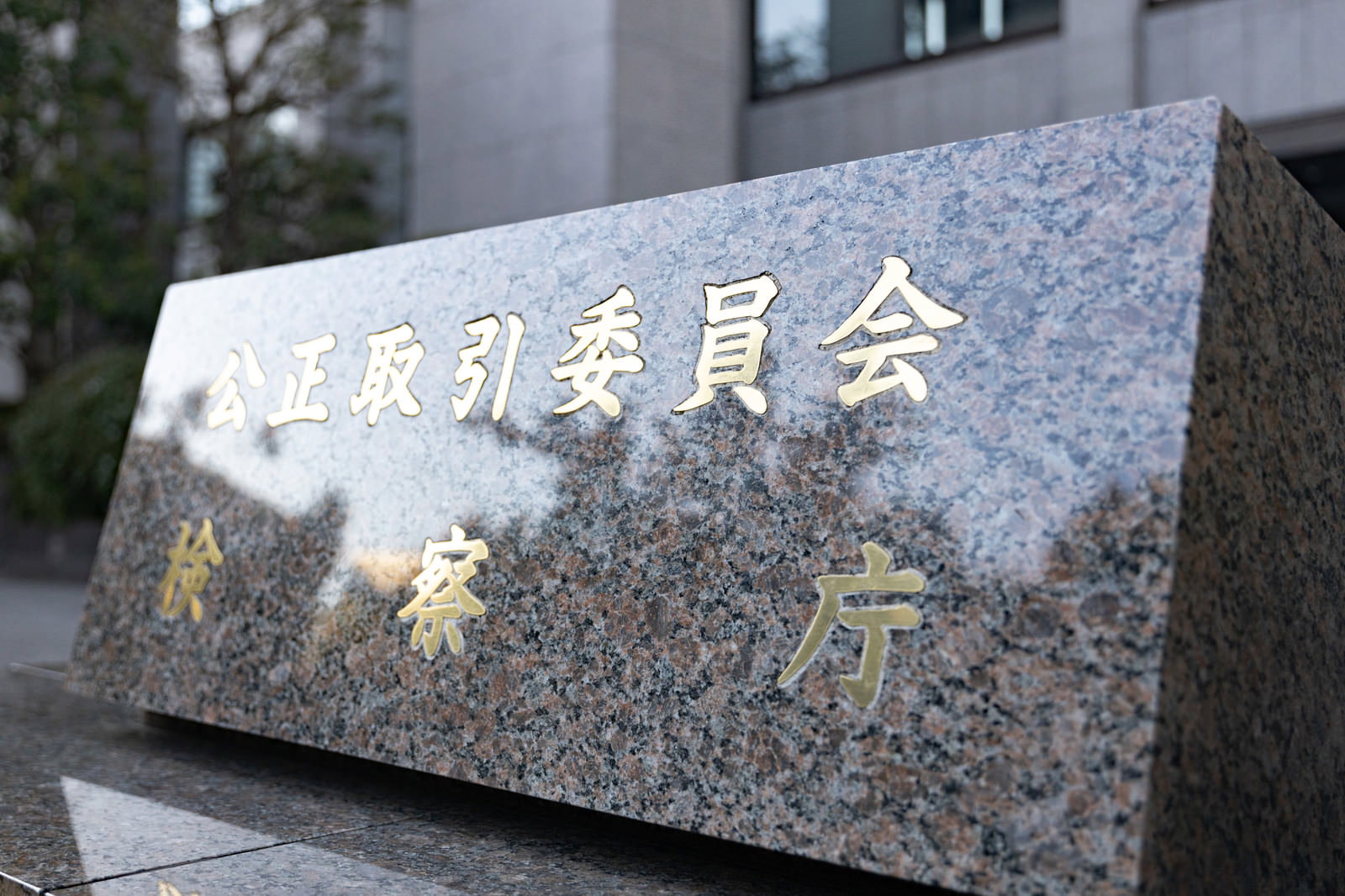 グレーの石材に白文字で公正取引委員会と検察庁と刻まれた銘板