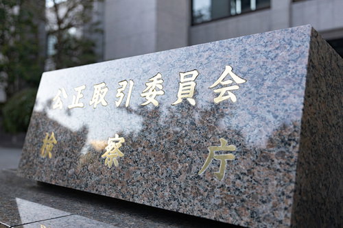 グレーの石材に刻まれた公正取引委員会と検察庁の銘板