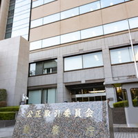 霞ヶ関の公正取引委員会銘板から見上げたビルディングの写真