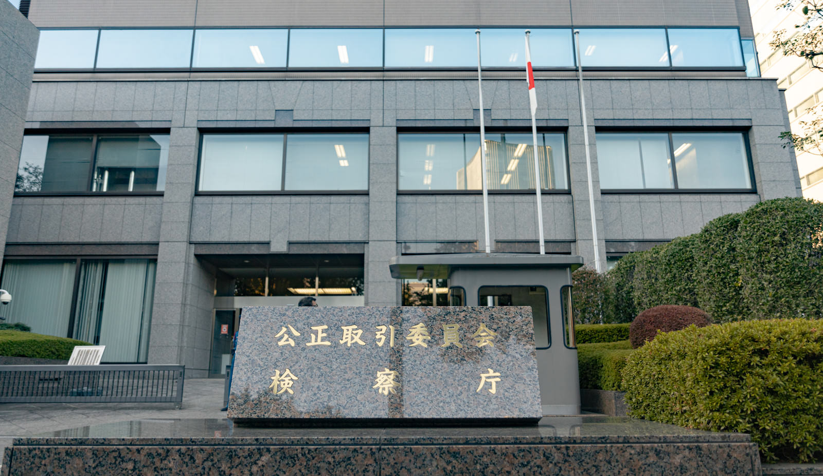 グレーの建物外壁に設置された公正取引委員会と検察庁の金属製銘板