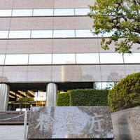 銘板越しに見る霞ヶ関の検察庁の厳格な庁舎建物の写真