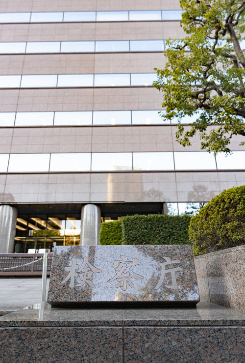 銘板越しに見る霞ヶ関の検察庁の厳格な庁舎建物