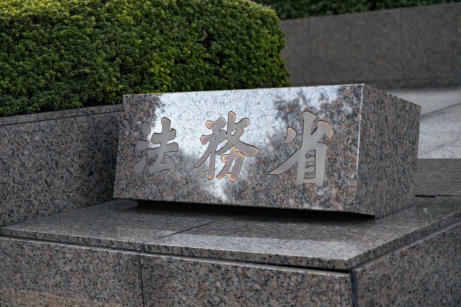 グレーの石材に彫り込まれた法務省の銘板