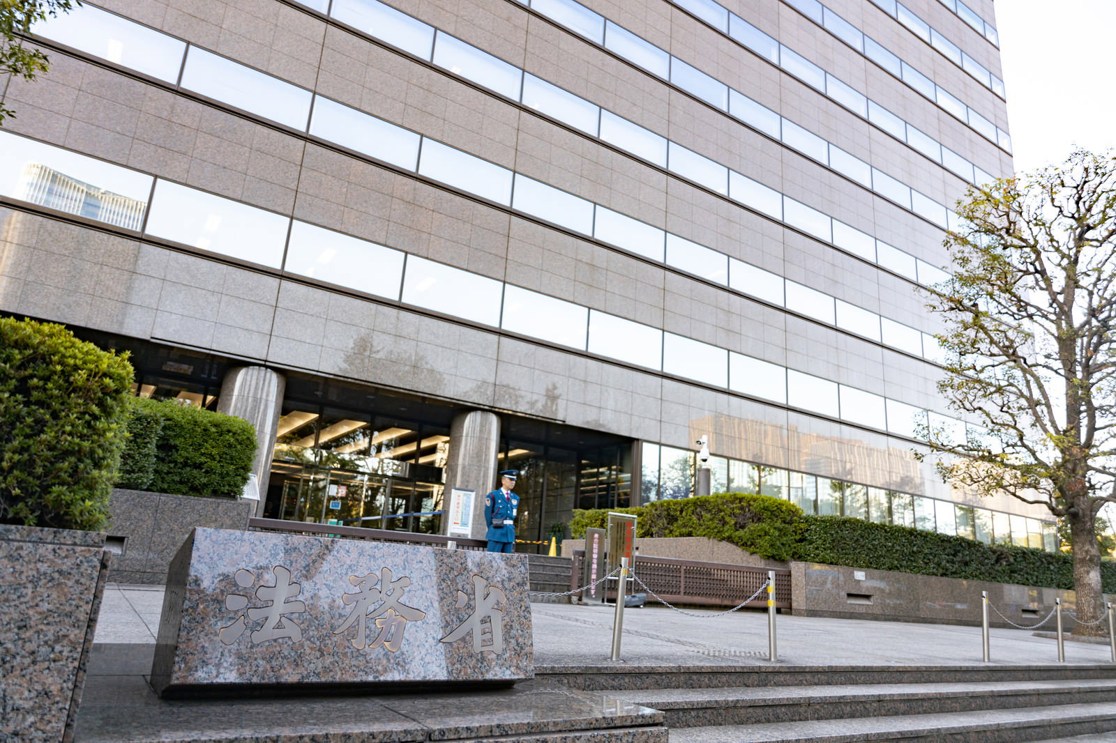 法務省の庁舎外観と正面に設置された銘板を撮影した写真