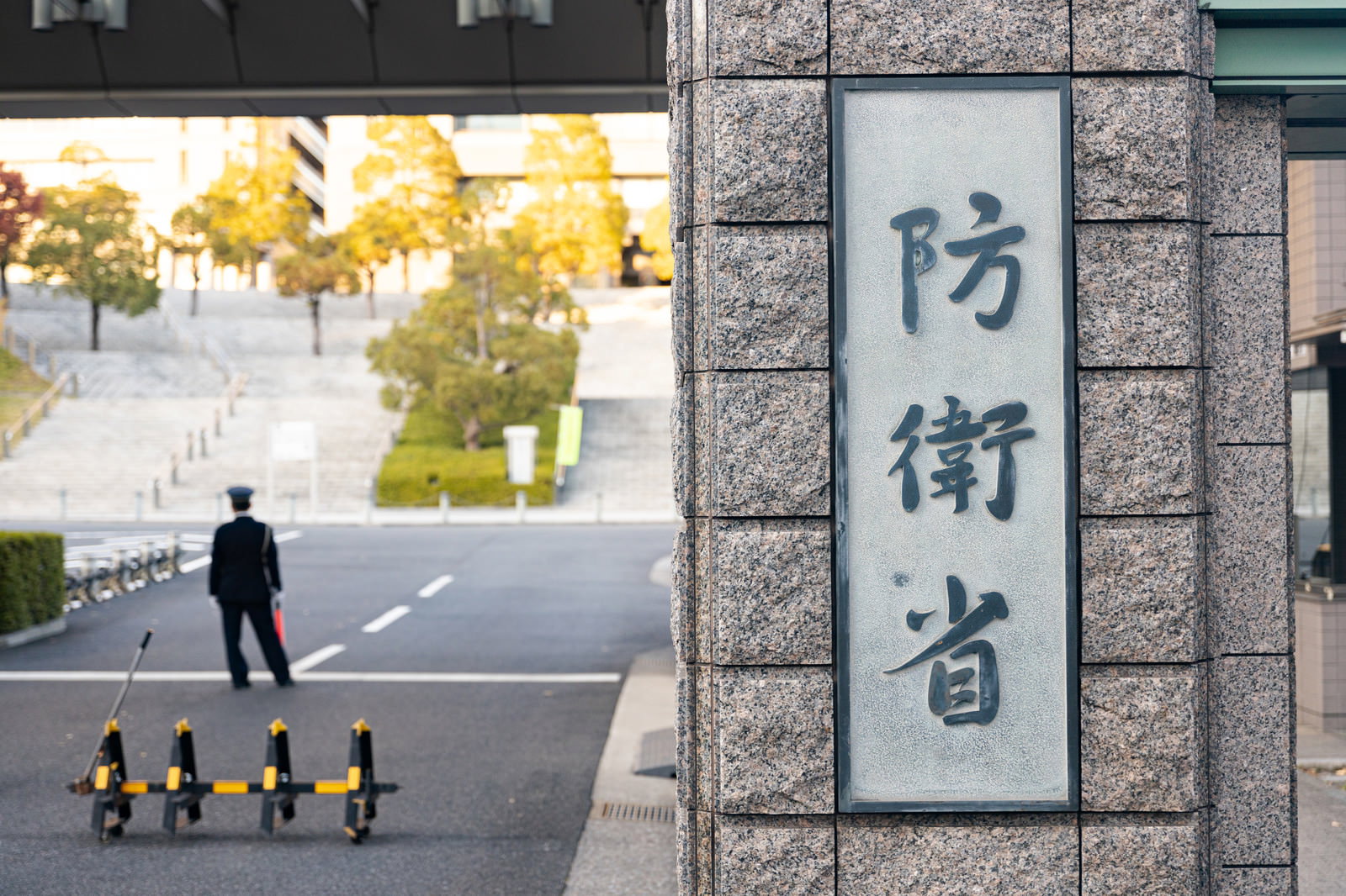 防衛省の正門にある石造りの門柱に設置された銘板と守衛