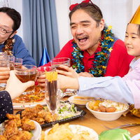 テーブルを囲んで乾杯する家族の団欒シーンの写真