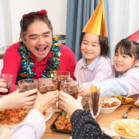 子どもたちとホームパーティーで乾杯する父親と家族の写真