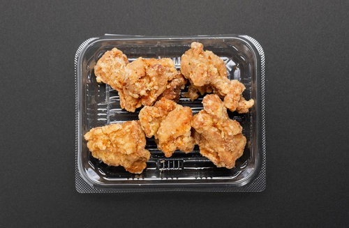 透明容器に詰められた揚げたての唐揚げ、鶏からあげの惣菜