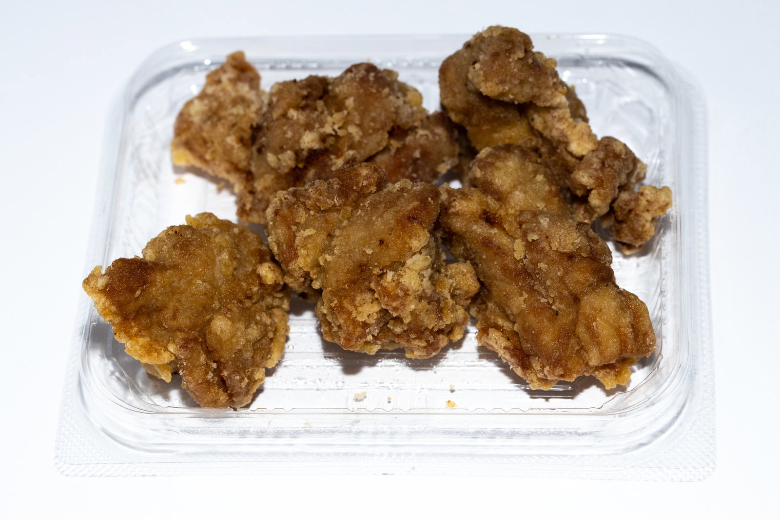白いトレーに盛り付けられた茶色い鶏の唐揚げ