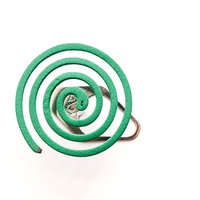 使用中の緑色渦巻き蚊取り線香と白い煙が立ちのぼる様子の写真