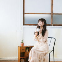 椅子に座って紅茶を飲んでひとやすみする女性の写真