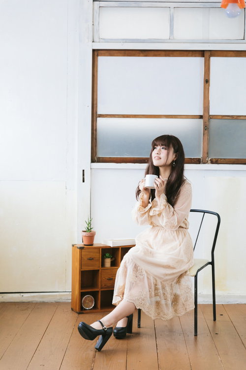 椅子に座って紅茶を飲んでひとやすみする女性