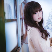 窓辺で遠くを見つめる悲しげな目つきの女性の写真